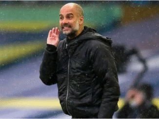 Pep Guardiola watches on under the rain — a familiar Premier League setting he joked about with Sean Dyche.
